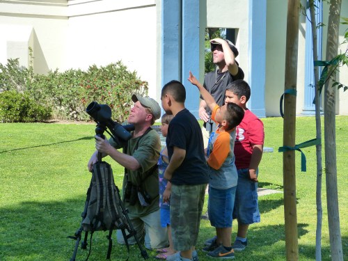 Dave Hursh, assisted by Zach Weber, gets great views of the parakeets for the kids in the park.