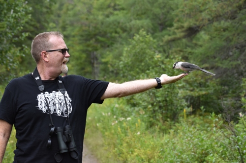 David makes friends with a Canada Jay. Photo by Derek Hudgins.